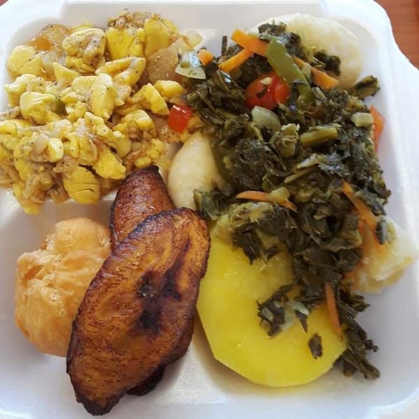 A Jamaican meal with ackee and saltfish, callaloo, fried plantains, and a fried dumpling.